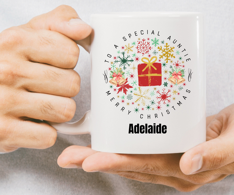Person holding a mug with a Christmas design and text, against a plain background