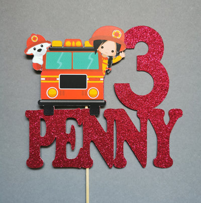 Fire truck and character cake topper with number 3 and name 'Penny' on a gray background