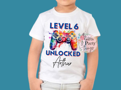 Child wearing a white t-shirt with a colorful gaming controller design and text on a blue background