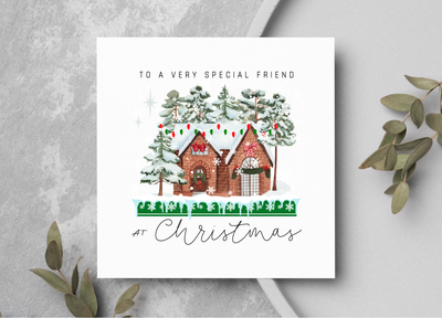 Christmas card with a festive house illustration on a gray surface.