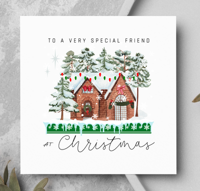 Christmas card with a festive house illustration on a gray surface.