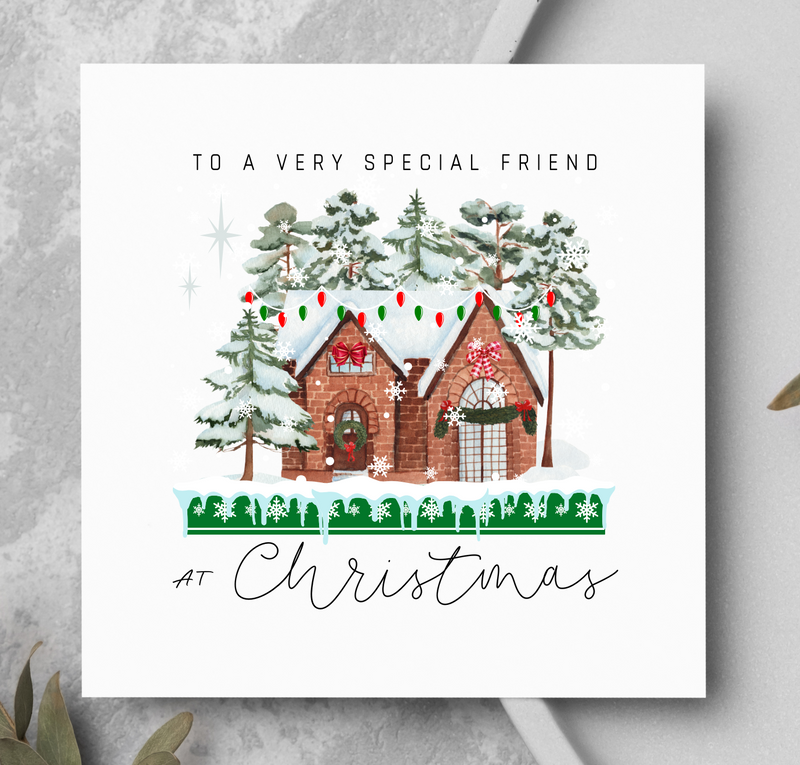 Christmas card with a festive house illustration on a gray surface.