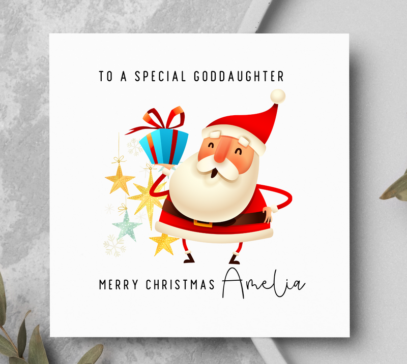 Christmas card with Santa Claus holding presents on a gray surface with greenery.